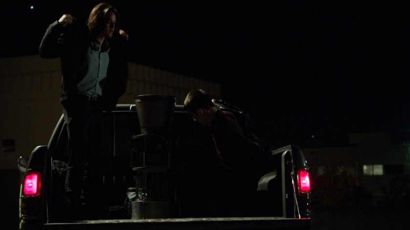 Seth and Donnie in a pickup truck on a parking deck.