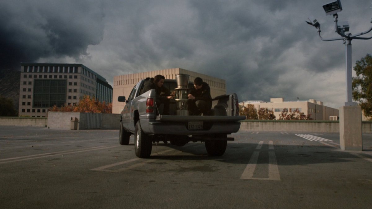 Seth and Donnie in a pickup truck on a parking deck.