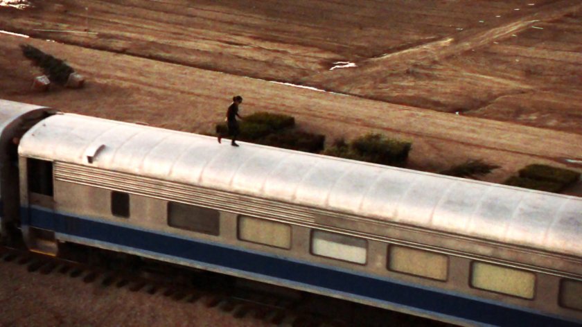 May running on top of a train in the Italian countryside.