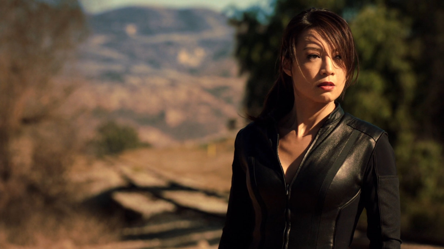 May standing on train tracks watching the train off screen.