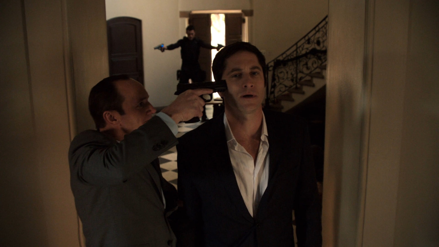 Coulson holding a gun to Ian Quinn's head.