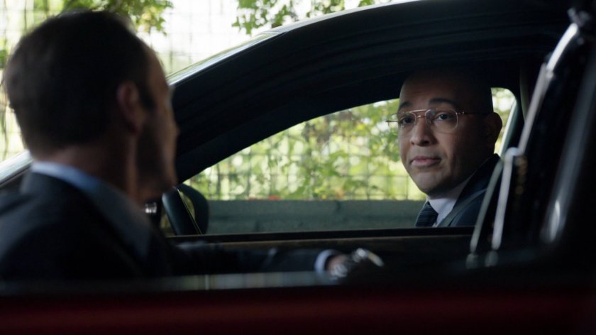 Coulson speaking to Sitwell in a parking garage.