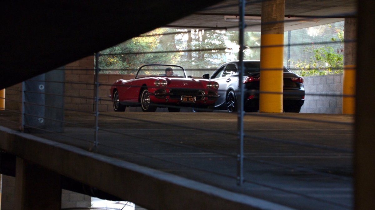 Coulson speaking to Sitwell from their cars in a parking garage.