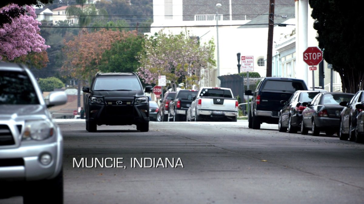 A SHIELD SUV driving towards camera on a town street. Text: Muncie, Indiana.