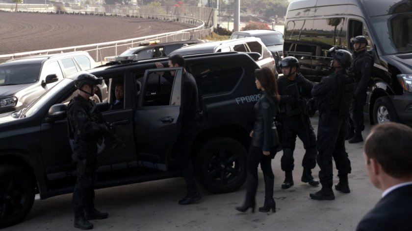 SHIELD agents milling around their vehicles at an abandoned racetrack.