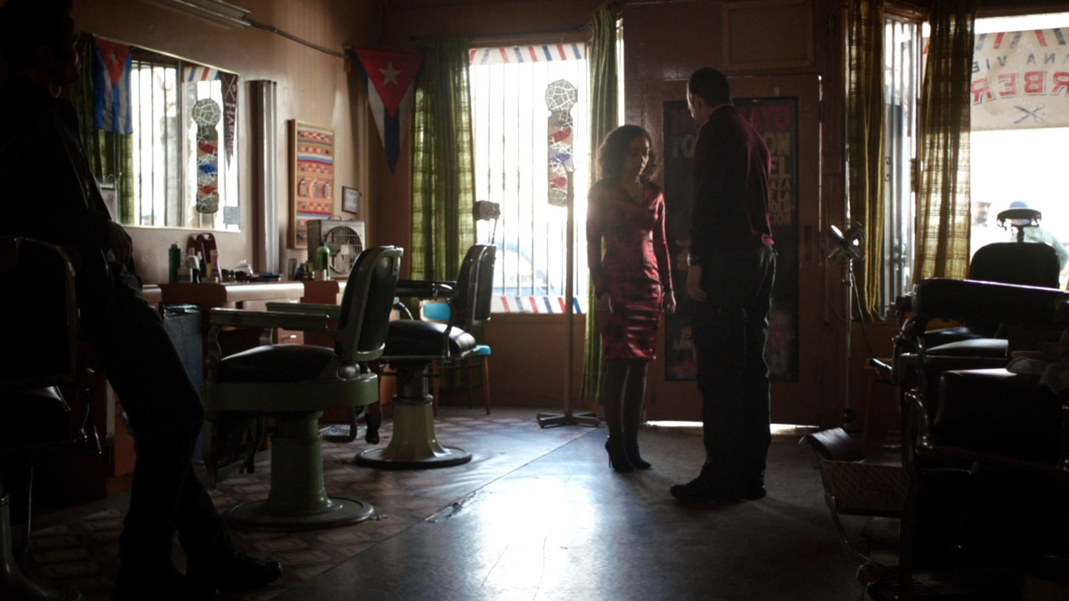 Garrett greets Raina in Cuban barber shop.