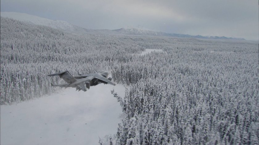 The Bus flies over a frozen and snowy forest.