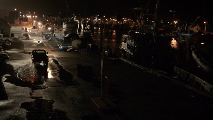 High angle view of blacked out dock with pickup truck driving away.
