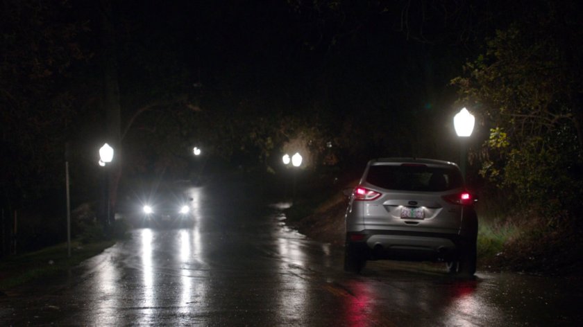 A car races away on a road in Portland park.