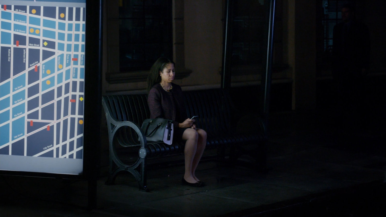 A woman on a bus bench in Washington DC.