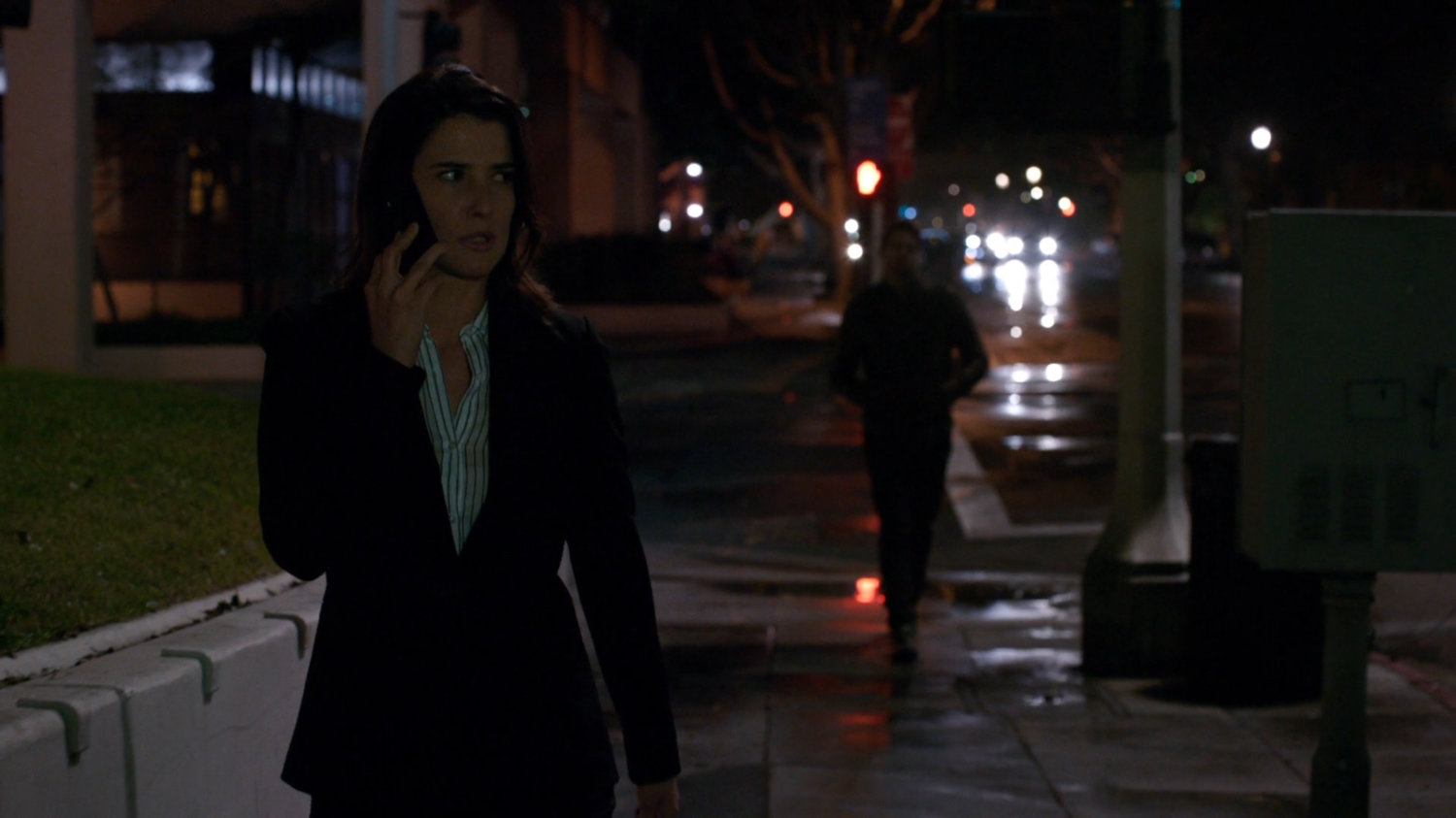 Maria Hill talking on the phone, on a sidewalk in Washington DC, being followed by a man.