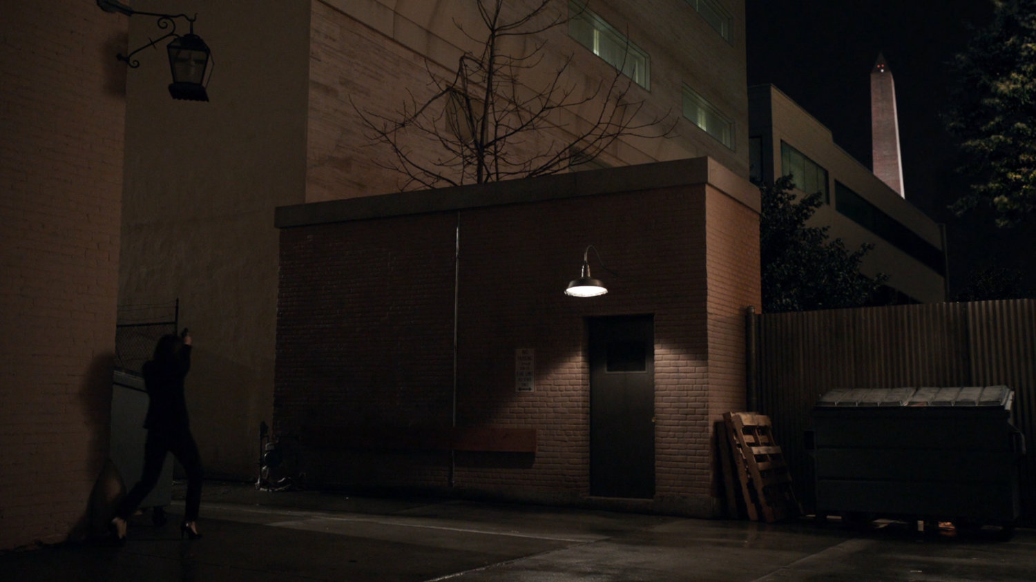 Maria Hill enters a dark alley in Washington DC.