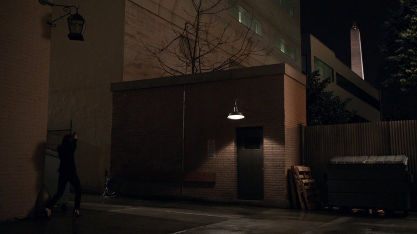 Maria Hill enters a dark alley in Washington DC.