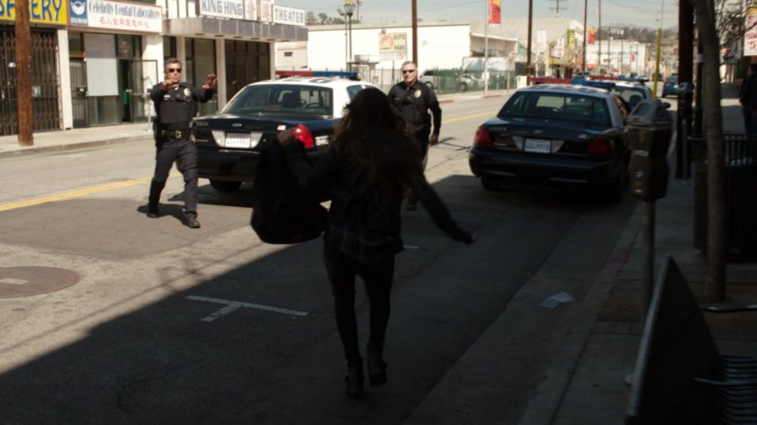 Skye walks into street towards two police officers.