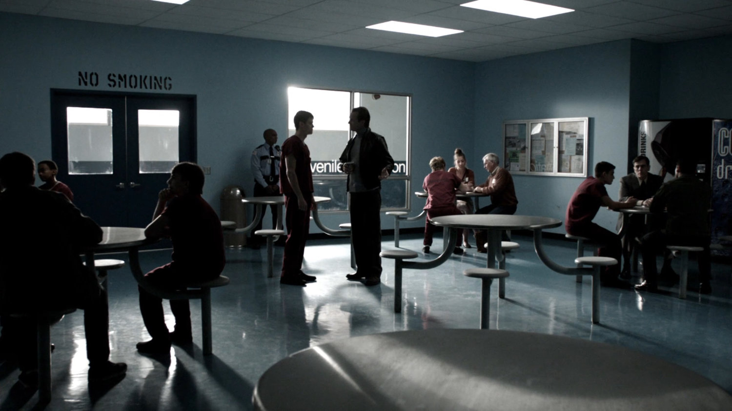 Interior of juvenile detention facility visitation room with John Garrett, young Ward and other inmates and guards.