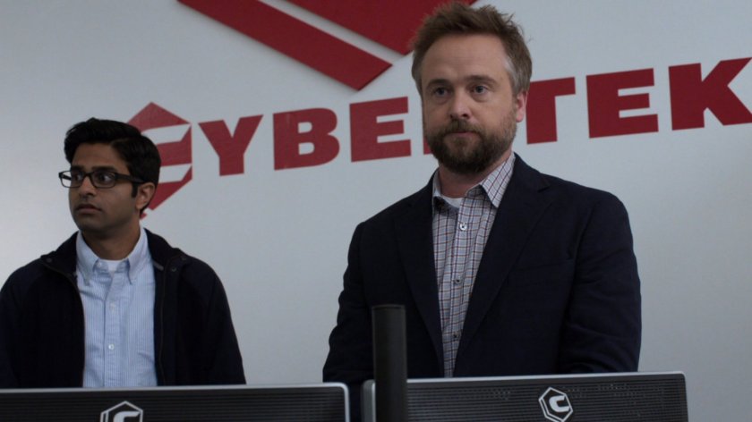 Kyle Zeller in front of the Cybertek log in their offices.