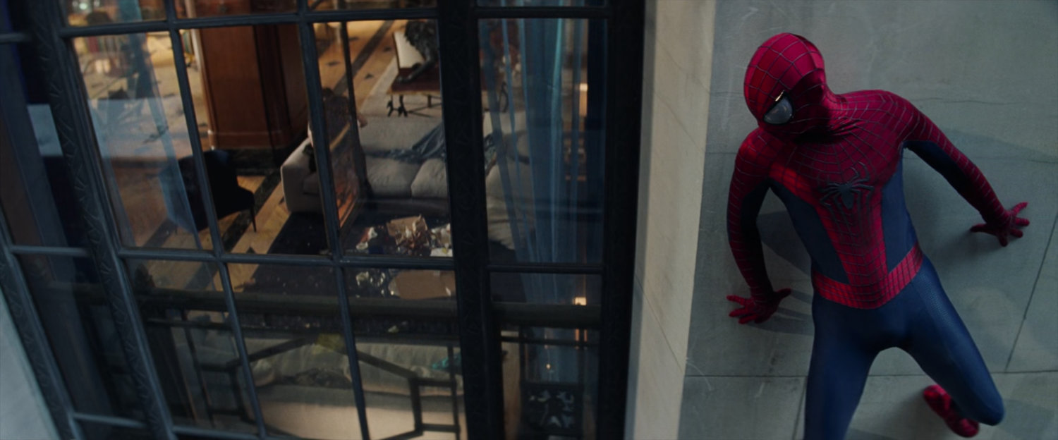 Spider-Man clinging to a wall outside Harry's apartment.