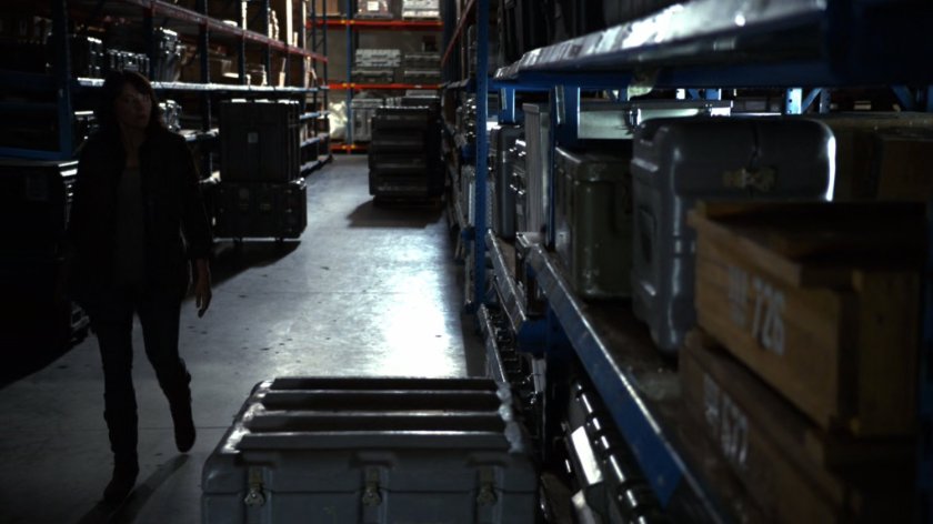 Agent Hartley in Marine Base warehouse aisle.