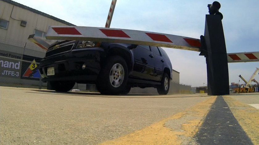 SUV crashing through barrier at security checkpoint.