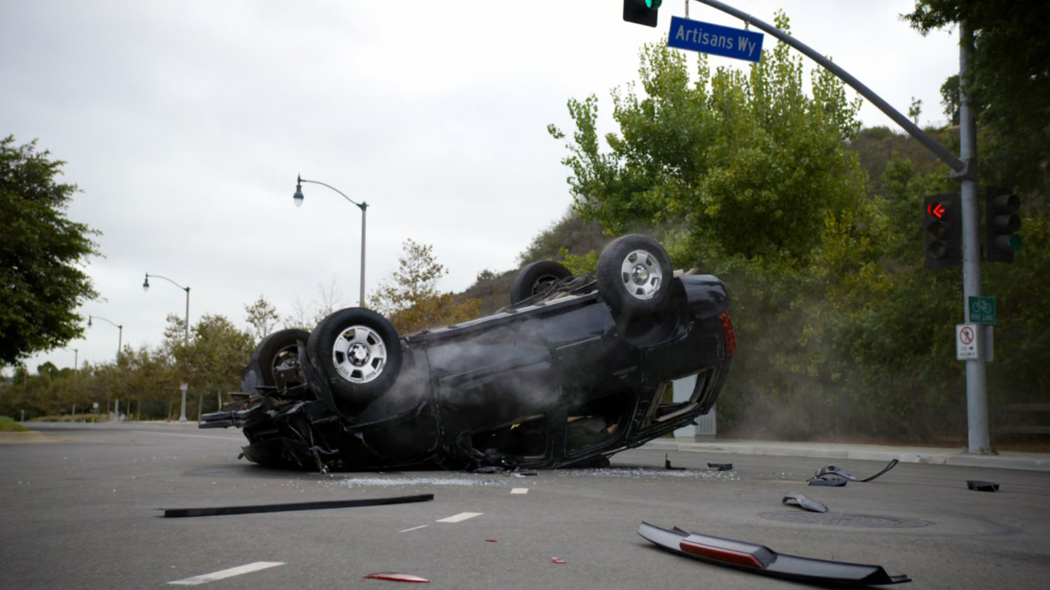 An upside down SUV in intersection.