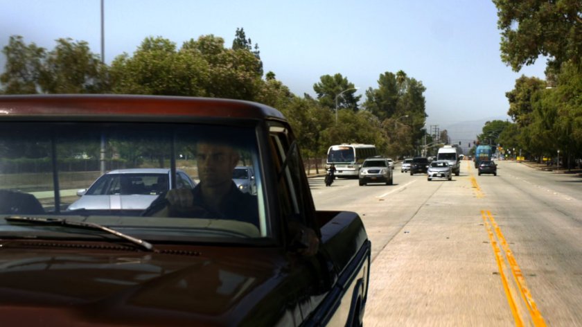 Agent May racing along a busy road on a motorcycle towards a pickup truck.