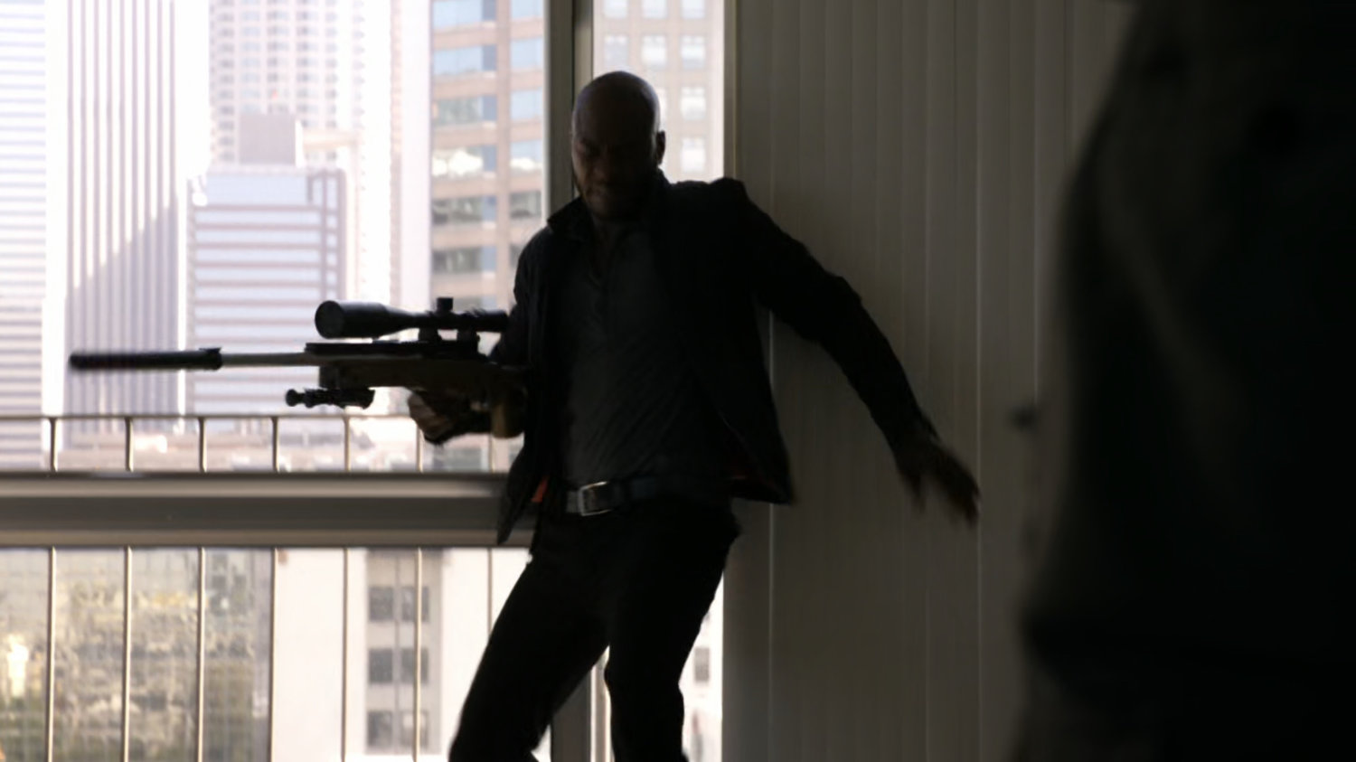 Triplett with sniper rifle on a balcony.