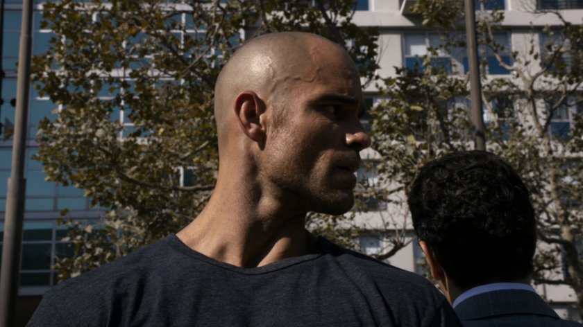 Closeup of Creel talking with Bakshi in a city park.