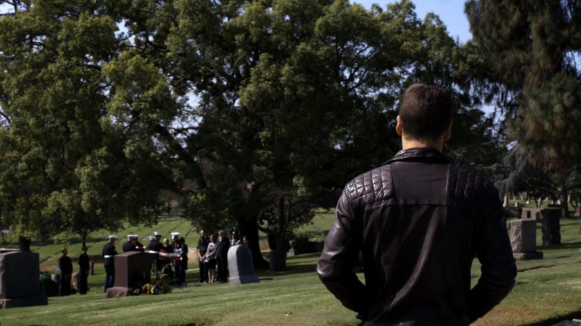 Hunter watching military service in cemetery.