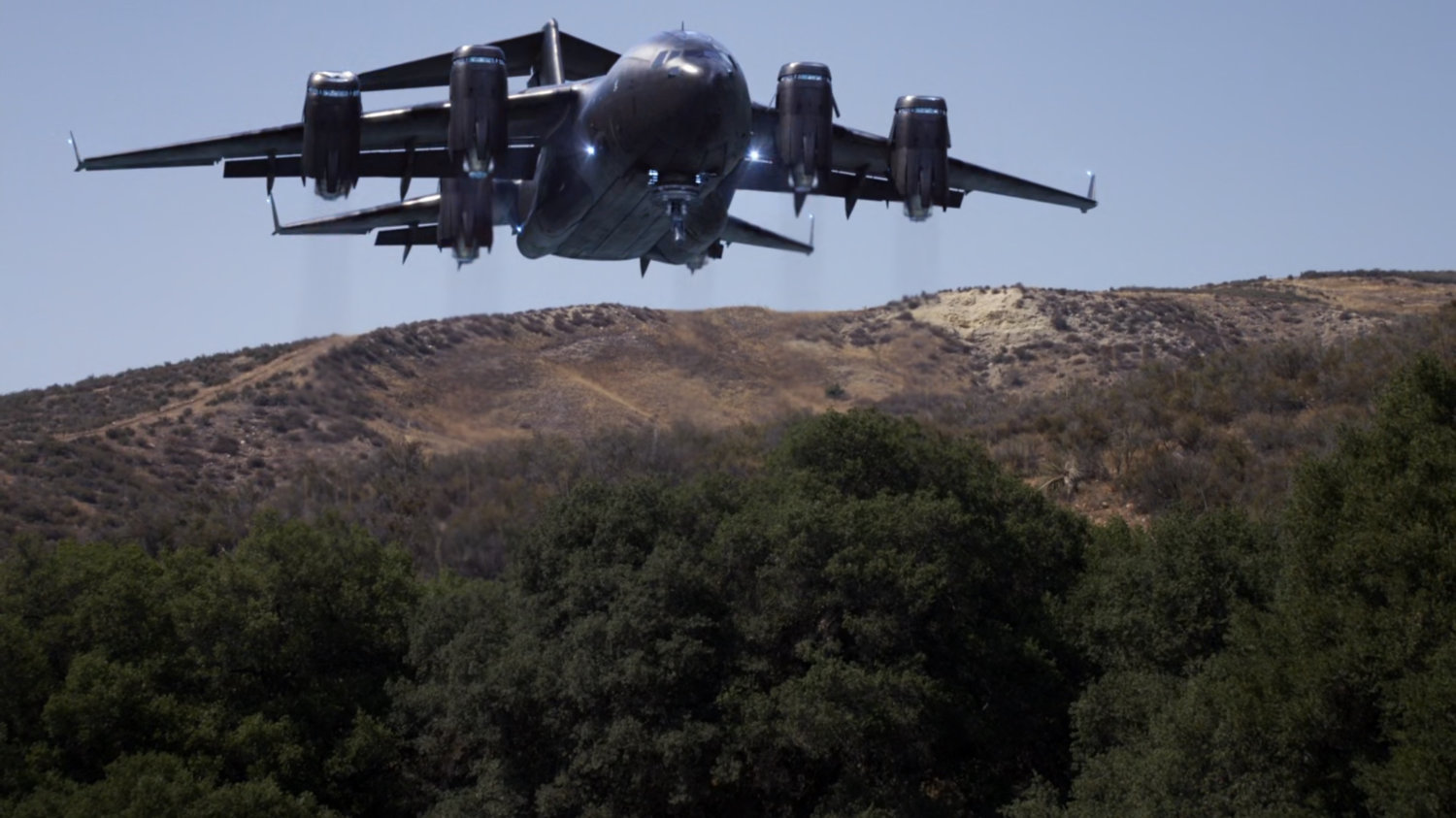 The Bus materializes above hills.