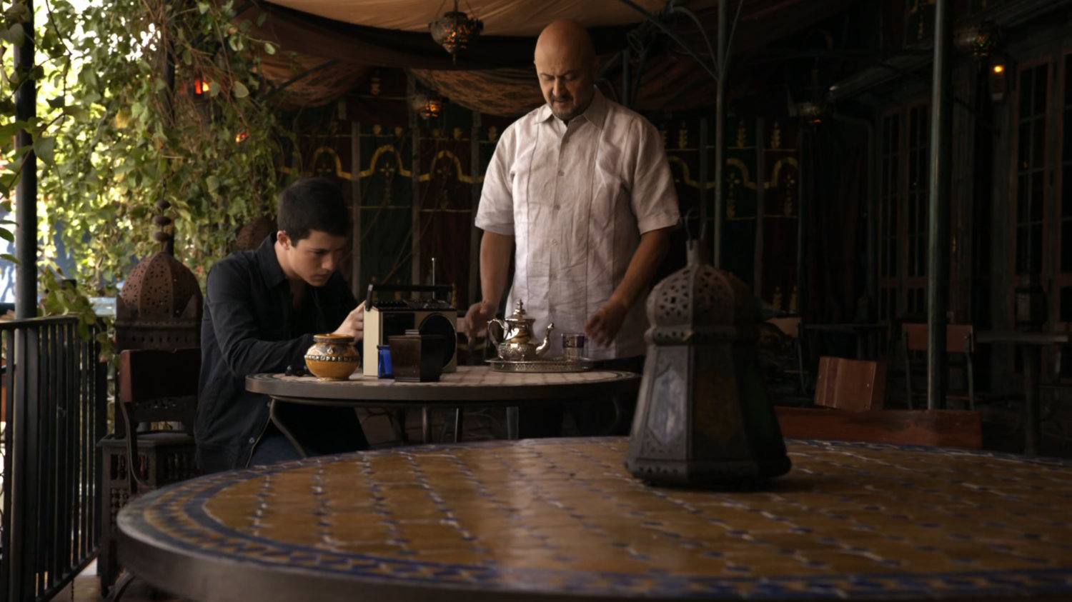 Waiter serving Donnie Gill beverage at outdoor dining are.