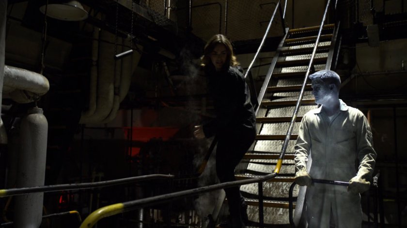 Simmons see frozen man on a dark hold in a ship.