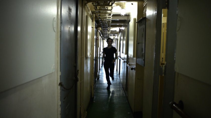 Simmons running through a ship hallway.