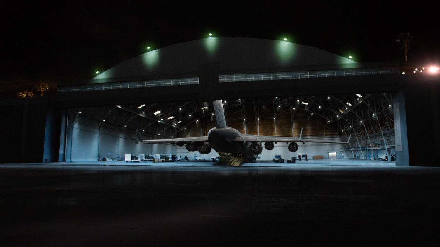 Airport hangar with The Bus inside, at night.