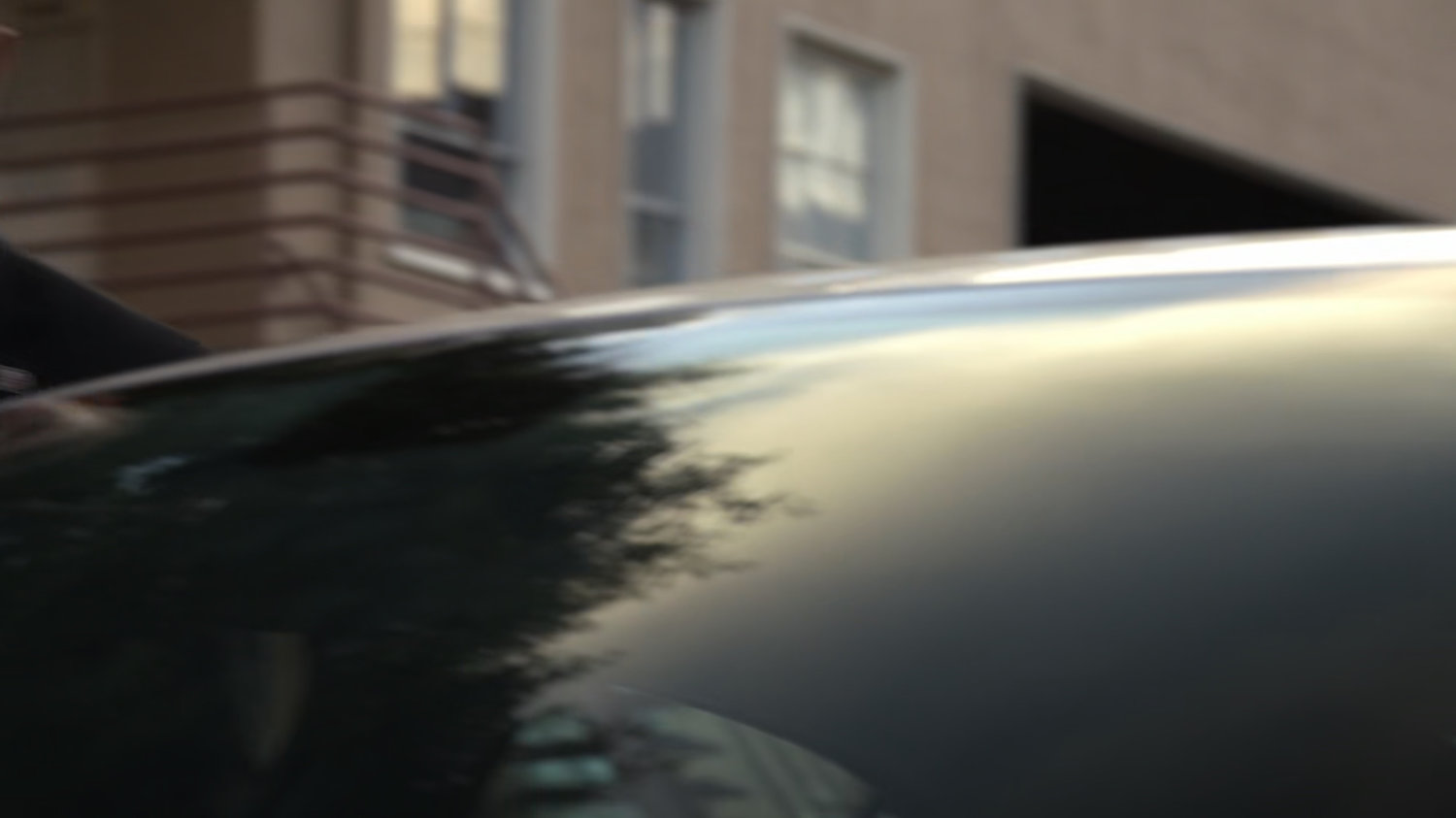 Raina's car with background building.