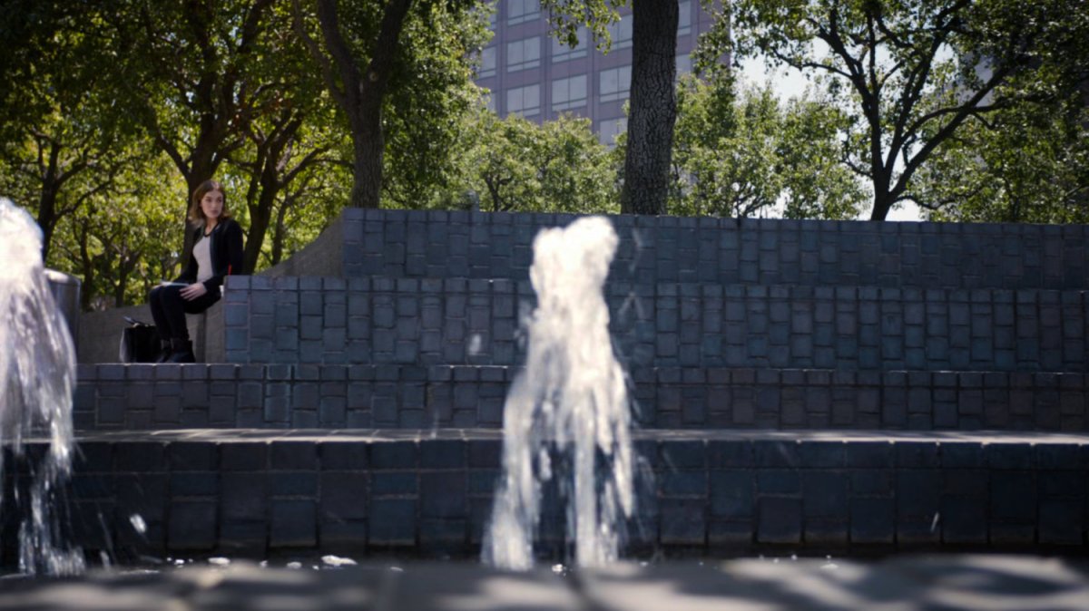 Simmons in a park by a water fountain.