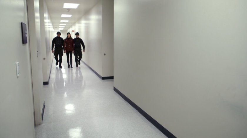 Guards walking down stark white hall in HYDRA Labs.