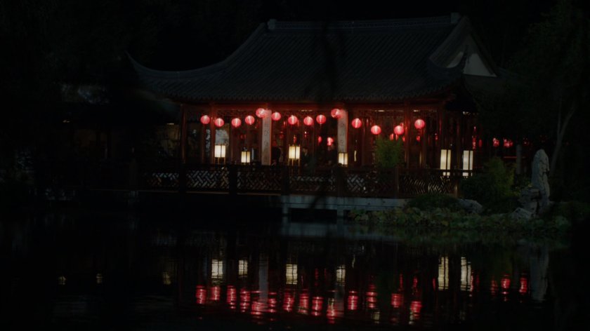 Japanese pagoda at night reflected in water.