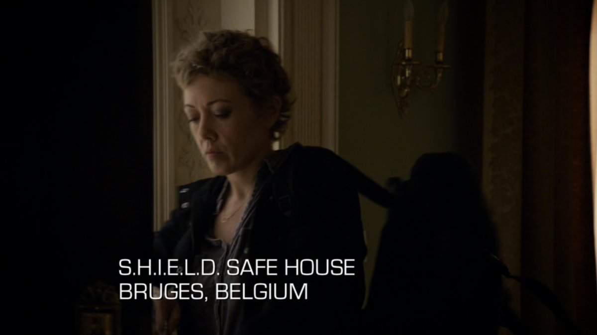 Agent Walters inside stately home. Text: SHIELD Safe House, Bruges, Belgium.