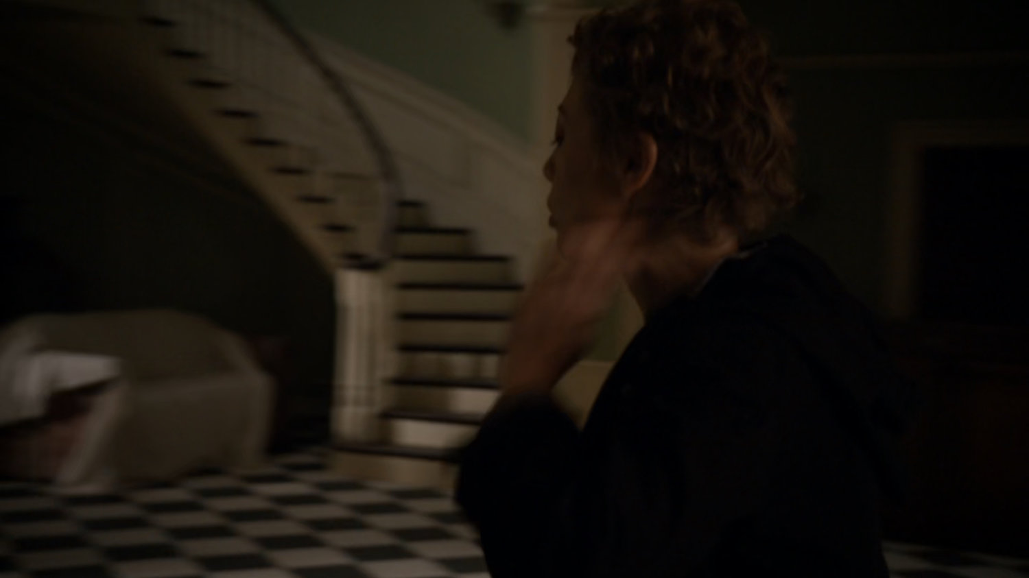 Agent Walters inside stately home foyer.
