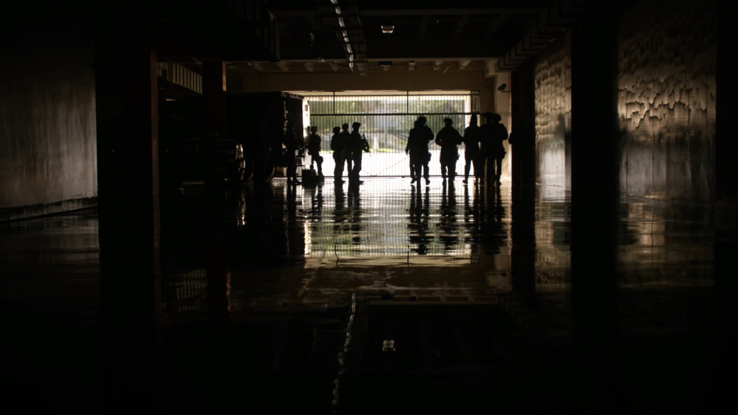 An dark underground garage with silhouettes.
