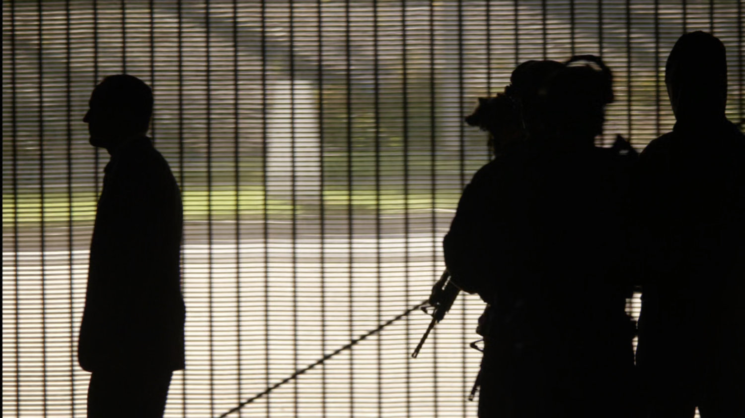 Silhouettes against a gated garage door.