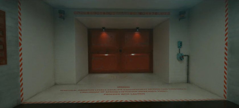 The doorway to the TVA Temporal Loom. Text: DANGER: Temporal Radiation Levels Escalate Exponentially Beyond This Threshold. Likelihood of Spaghettification Increases 7000%. Proceed With Caution.