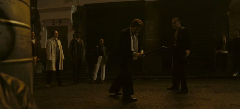 Brad grabbing a pipe on a dark London street.