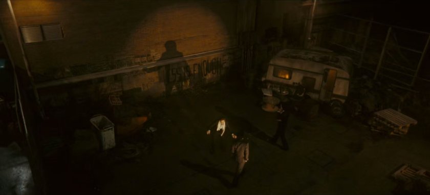 Loki confronting Brad in dark abandoned lot.