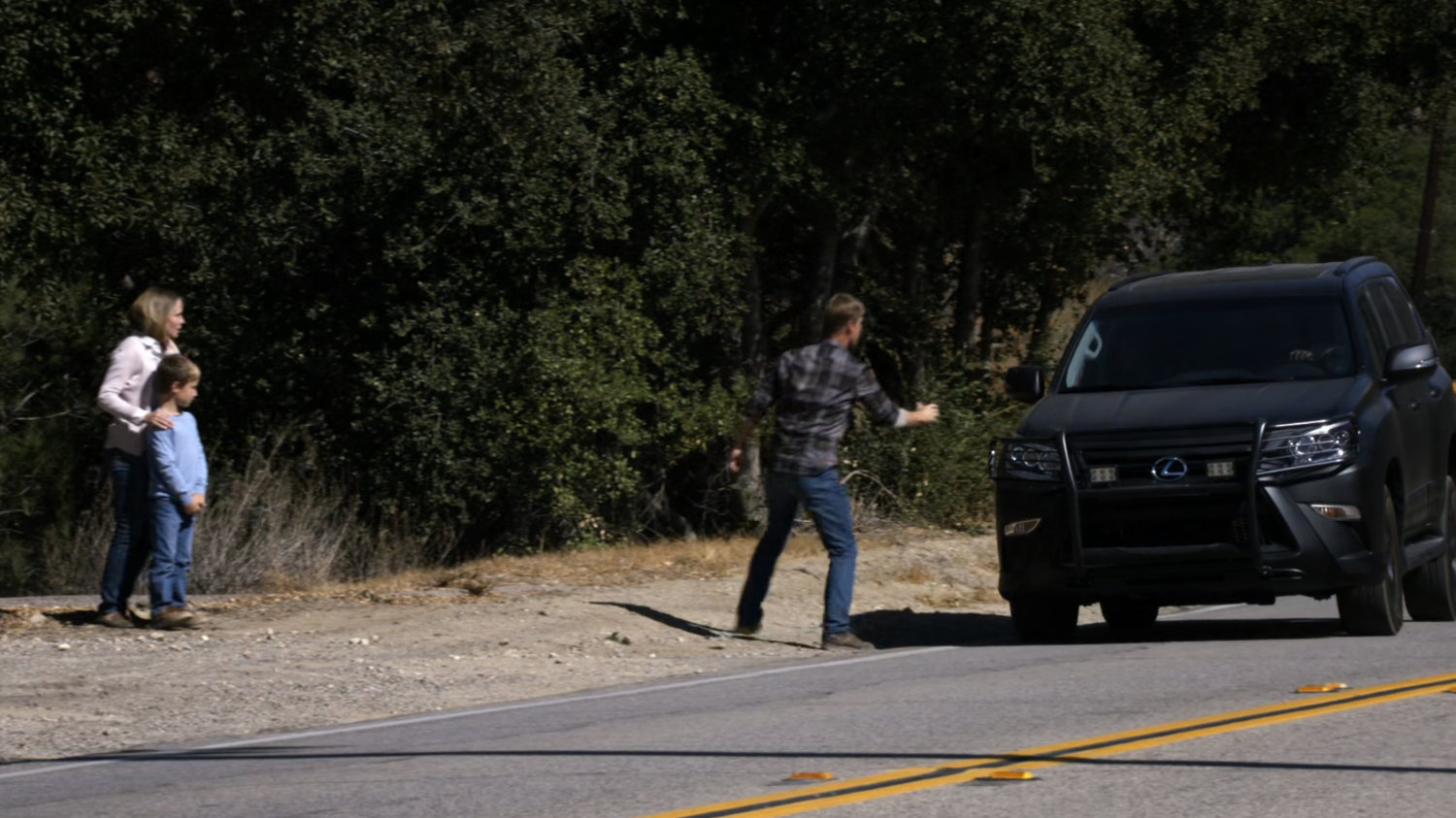 Hank Thompson flags down a SHIELD SUV on a rural road outside his house.