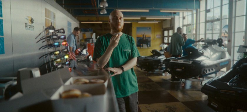 Man eating donut inside of Piranha Powersports.