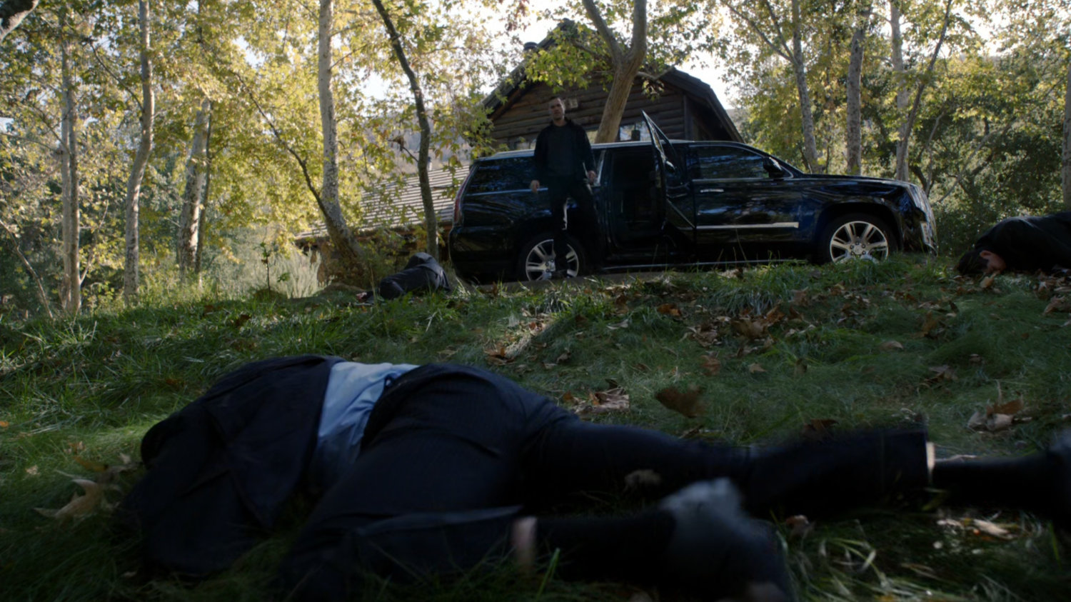 A black SUV outside a cabin in the Massachusetts woods.