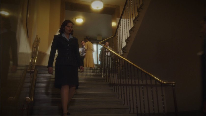 Peggy walks down steps in Roxxon Corporate building.