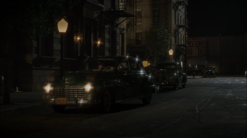 Car parks on dark New York city street across from The Griffith Hotel.