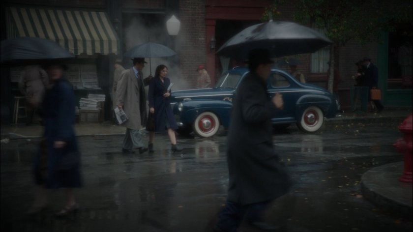 Peggy and Jarvis cross a rainy street in New York.